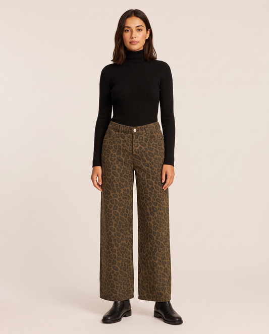 Woman wearing leopard print wide-leg trousers with a black ribbed turtleneck and black Chelsea boots, studio front
