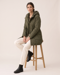 Plush-Lined Hooded Parka with Drawstring Hem — worn seated