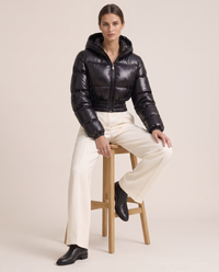 Glossy Cropped Puffer Jacket with Hood — worn seated