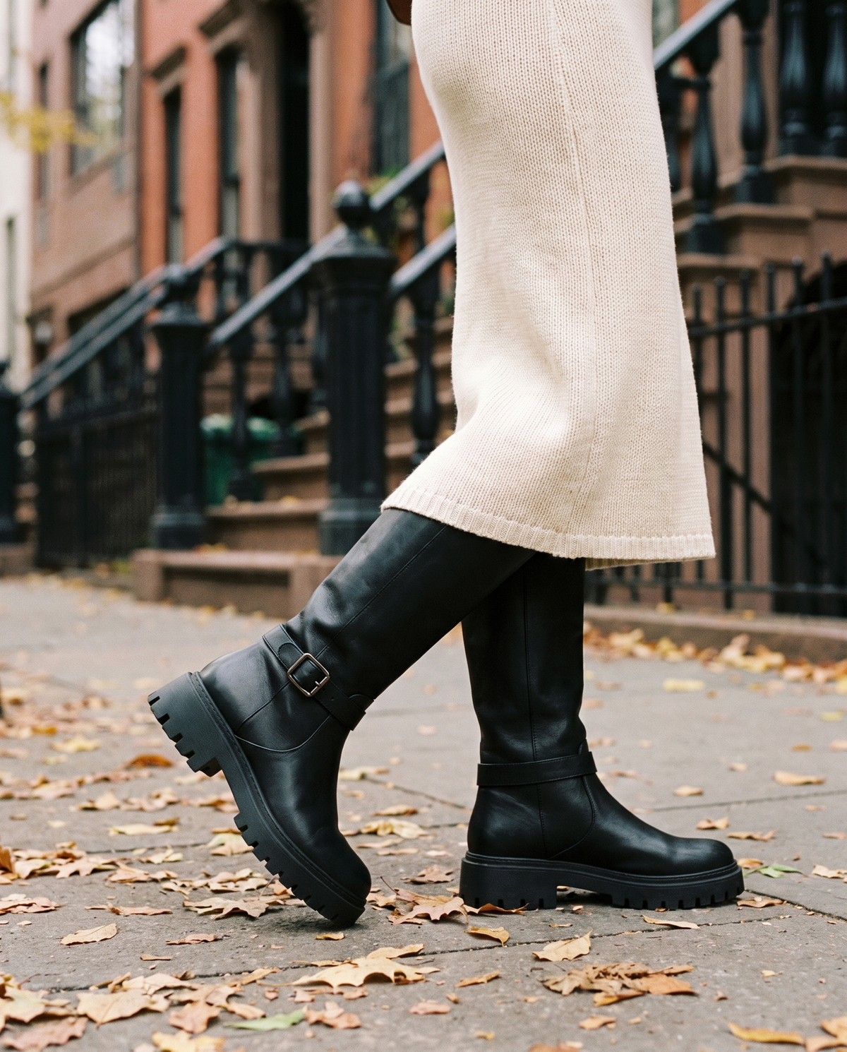 Knee-High Boots with Buckle Strap and Lug Sole — walking on a New York street in autumn