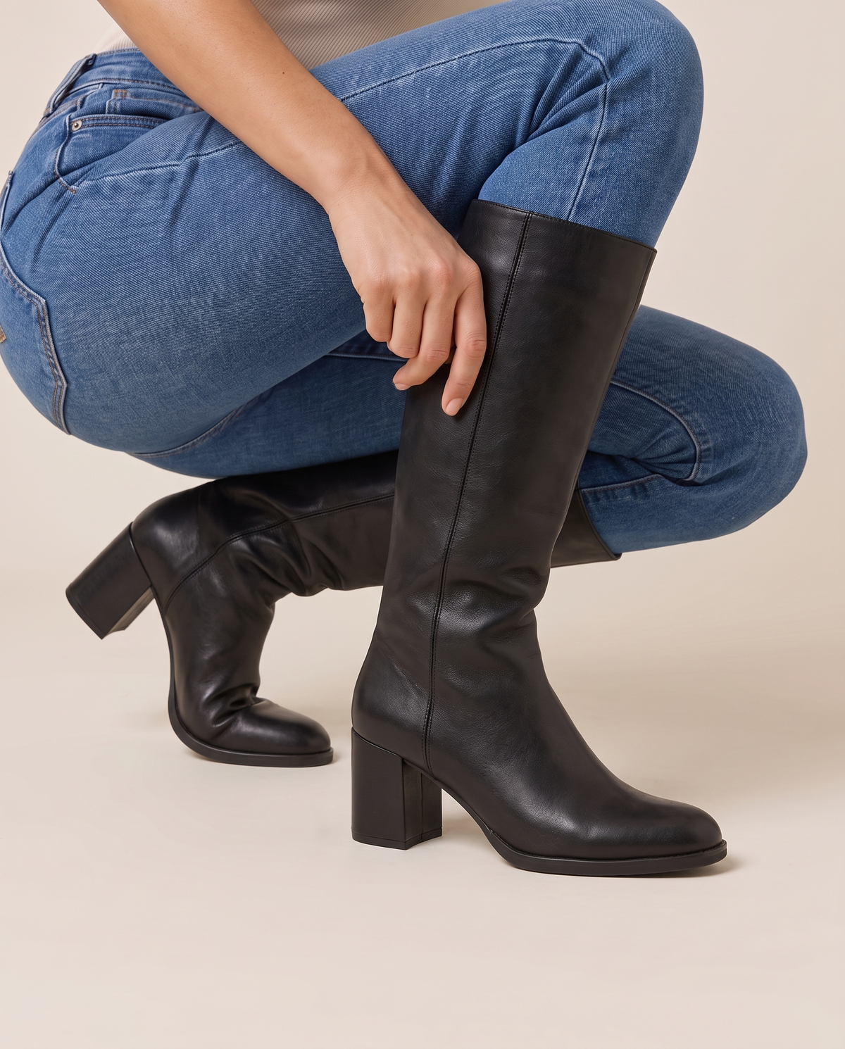 Round Toe Knee-High Boots with Block Heel — pulling on the boot with jeans
