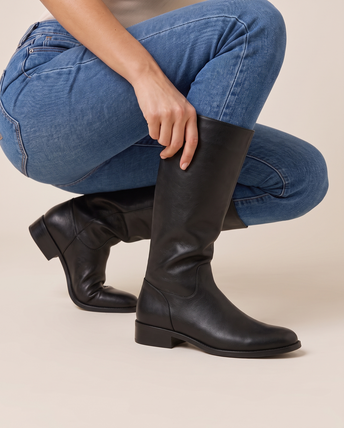 Pull-On Knee-High Boots with Cushioned Footbed — pulling on the boot with jeans