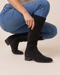 Knee-High Boots with Cushioned Footbed and Side Zipper — pulling on the boot with jeans