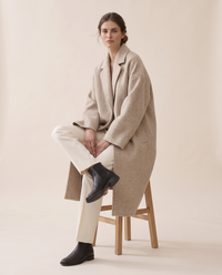 Oversized Wool-Blend Coat with Dropped Shoulders — worn seated