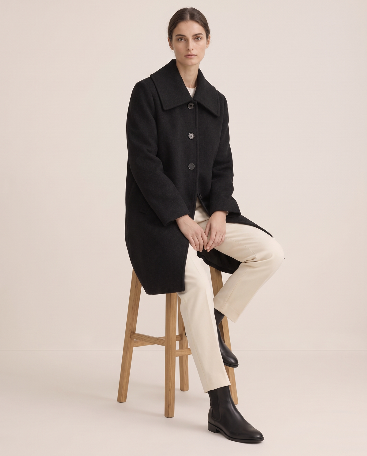 Black Wool Coat with Square Collar — worn seated