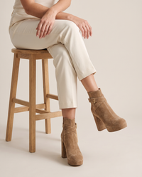 Block Heel Ankle Boots with Crossover Buckle Strap — worn seated