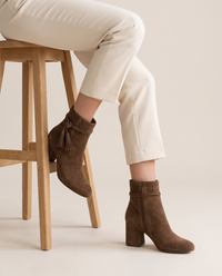 Block Heel Ankle Boots with Tassel Wrap Straps — worn seated