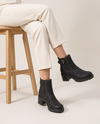 Chelsea Ankle Boots with Buckle Strap and Lug Sole — worn seated