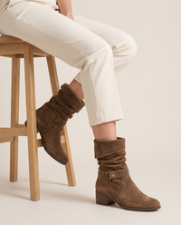 Suede Slouch Ankle Boots with Fold-Over Cuff — worn seated