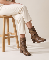 Distressed Ankle Boots with Buckle Straps — worn seated