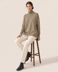 Erice Relaxed Loose-Fit Fine Knit Turtleneck Sweater — worn seated