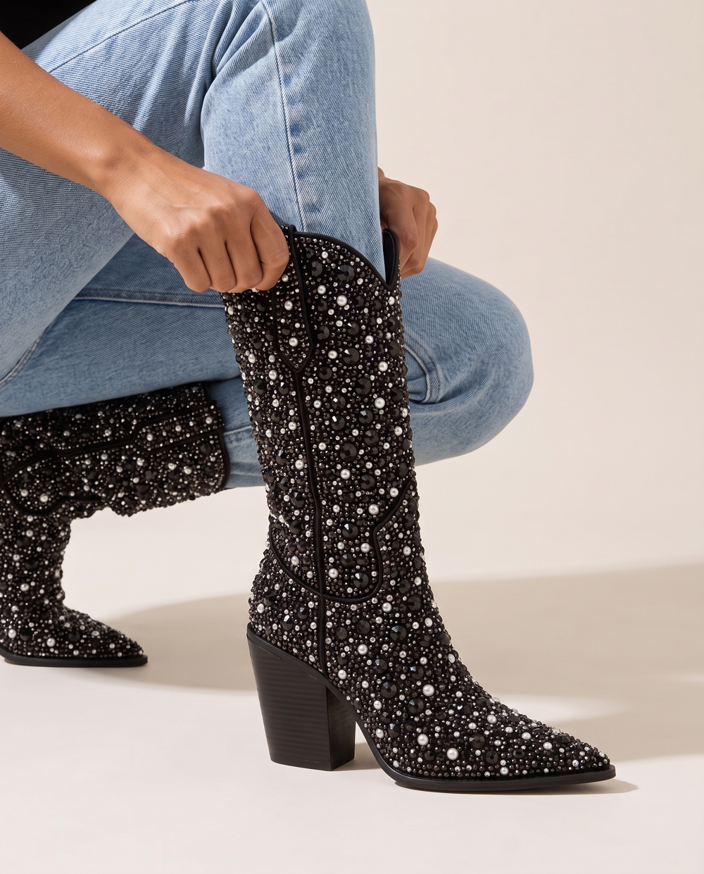 Rhinestone Cowboy Boots Mid-Calf in Black — pulling on the boot with jeans