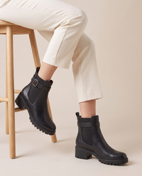 Pull-On Ankle Boots with Buckle Strap and Lug Sole — worn seated