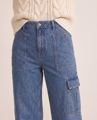 Close-up of the patch pockets and cargo pocket on blue cropped jeans