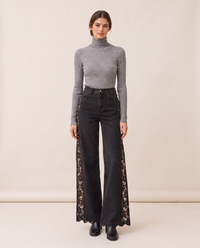 Black lace-inset wide-leg jeans with a grey turtleneck