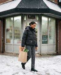Oversized Hooded Puffer Jacket for Women — carrying groceries out of a Brooklyn corner store in light snow