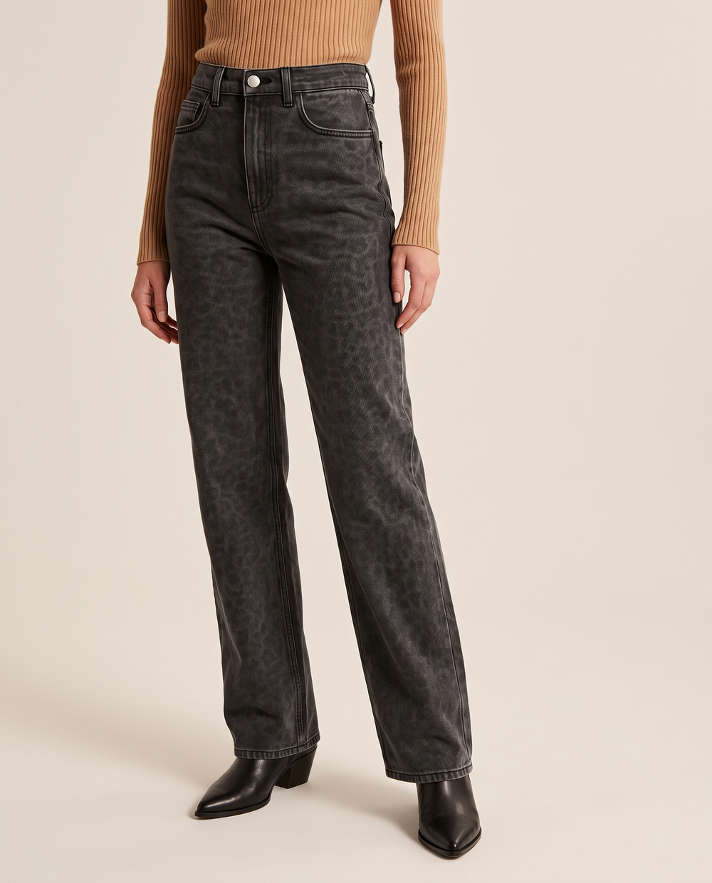 Black leopard print straight-leg jeans, waist-down three-quarter view with a camel ribbed turtleneck and black ankle boots