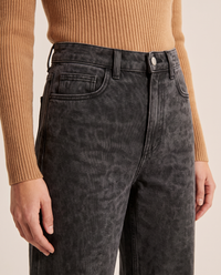 Close-up of the high waist, button and front pocket on black leopard print jeans