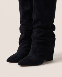 Women's Black Slouchy Suede Knee High Boots — pointed toe and hidden wedge heel, on foot