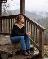 Ischia Relaxed Off-Shoulder Cable Knit V-Neck Sweater — with tea on a Vermont cabin porch