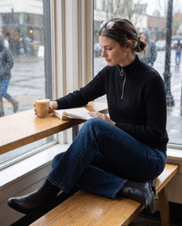 Kestrel Sleek Ribbed Half-Zip Mock Neck Sweater — reading in a café on a rainy afternoon