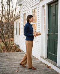 Women's Cashmere Crew Neck Sweater in navy worn arriving with a pie at a New England farmhouse for Thanksgiving