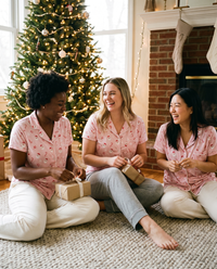 Women's Christmas Pajama Top, Pink Santa Print — girlfriends opening presents by the tree on Christmas morning