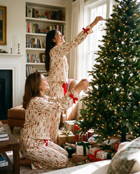 Women's Christmas Pajamas, Satin Bow-Cuff PJ Set — mother and daughter in matching Cream Nutcracker pajamas decorating the tree