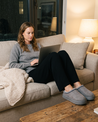 Women's Faux Suede Platform Slippers in gray worn while working from home on the sofa on a winter evening