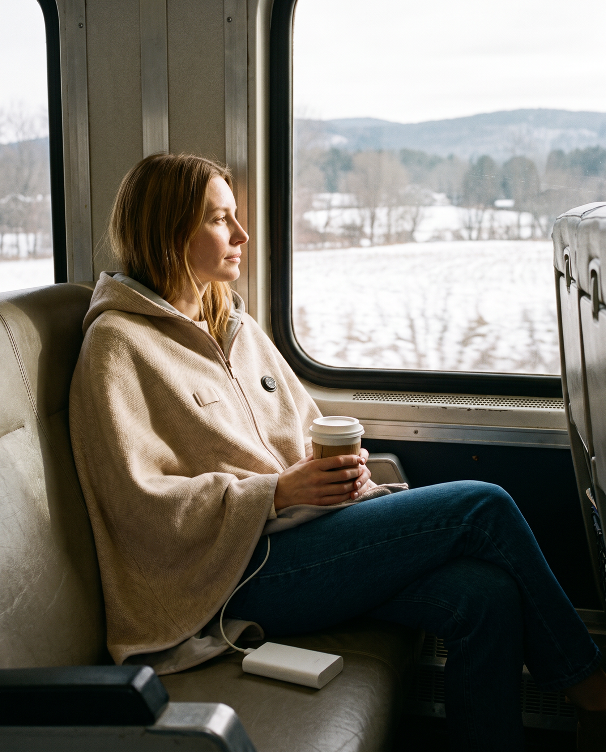 Heated poncho wrap worn on a winter train trip through snowy New England
