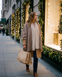 Women's Oversized Cashmere Wrap Scarf worn over a camel coat while holiday shopping