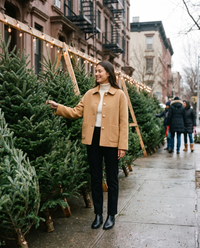 Women's Cropped Cashmere Coat in camel worn while choosing a Christmas tree on a Brooklyn sidewalk