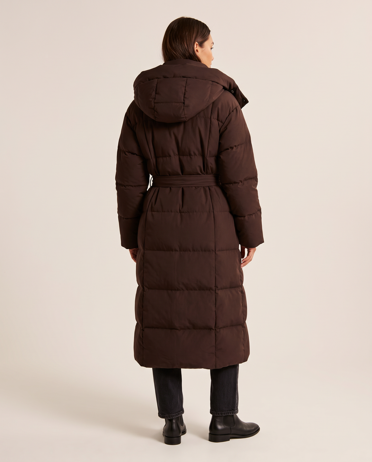 Women's Long Belted Puffer Coat in chocolate brown — studio back view with hood