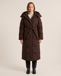 Women's Long Belted Puffer Coat with Oversized Hood in chocolate brown — studio front