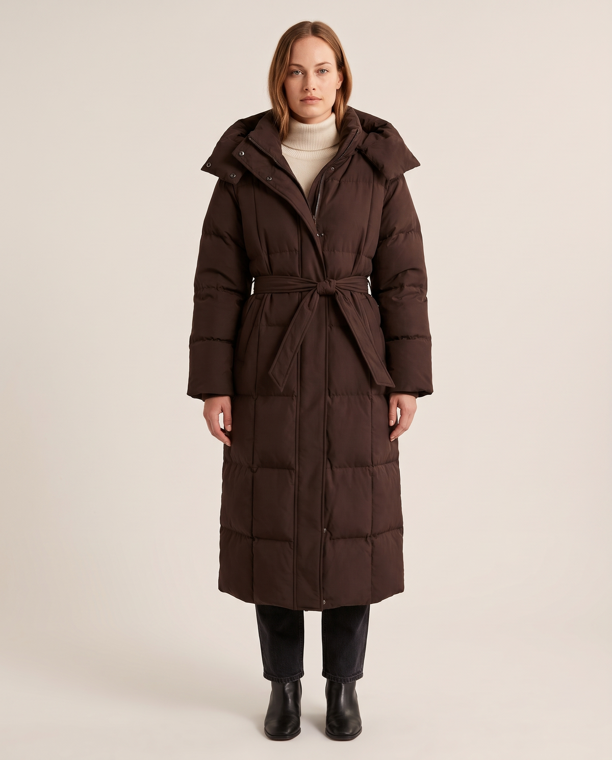 Women's Long Belted Puffer Coat with Oversized Hood in chocolate brown — studio front