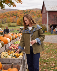 Olive plaid cape trench jacket worn at an autumn farm stand