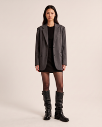 Slouchy knee-high biker boots in black faux leather, studio front