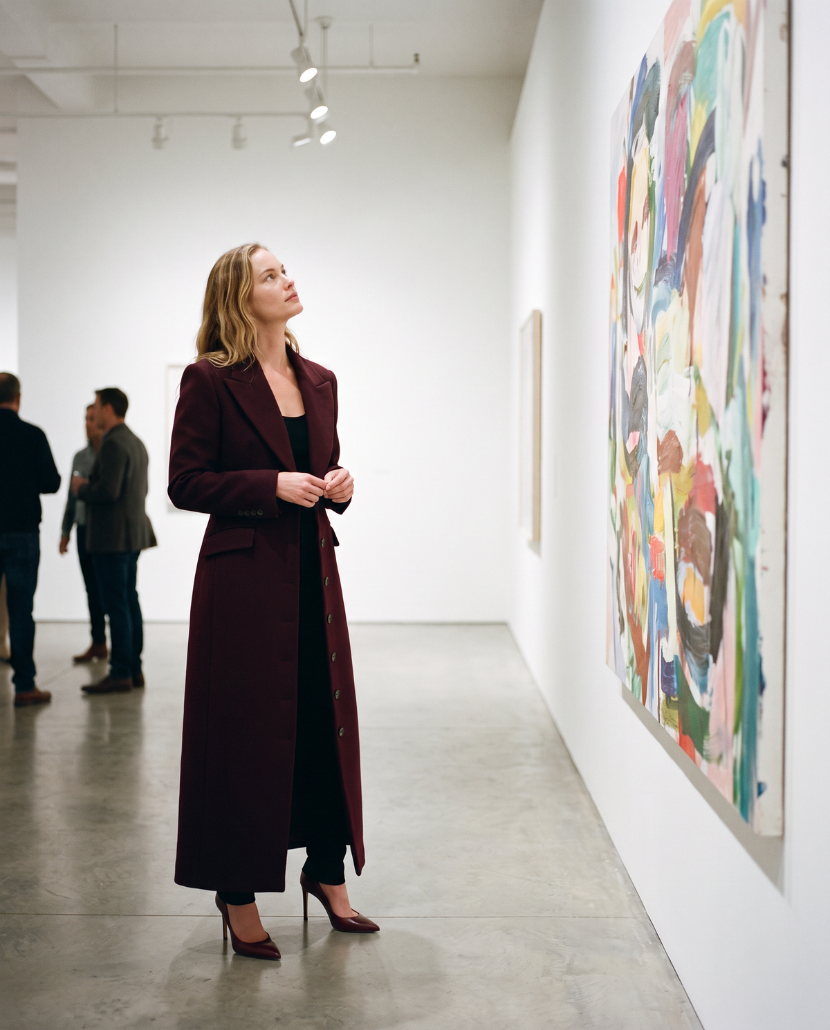 Burgundy tailored maxi wool coat worn in a New York art gallery