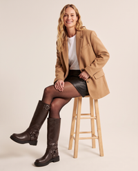 Knee high moto boots for women, seated side view